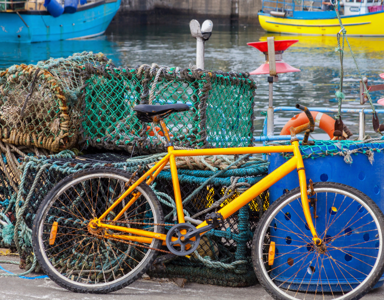 A stock photo of a bike and fishing boats representing rural Scotland.