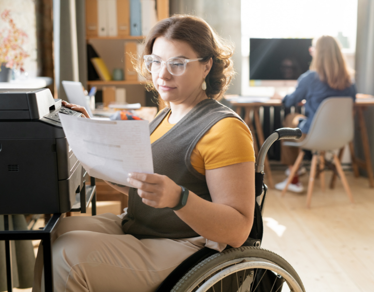A stock photo showing a disabled woman in a wheelchair at work.