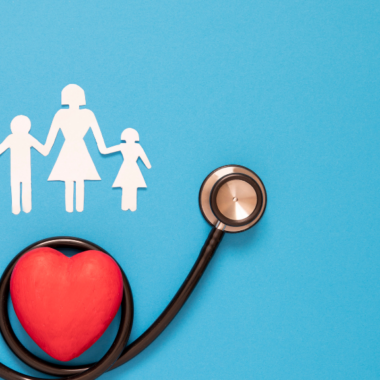 A stock image showing a stethoscope with red hearts and paper cut-out family. Representing health protection.
